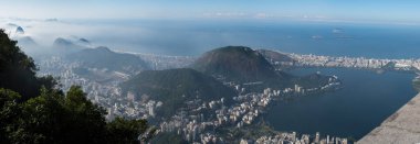 Rio de Janeiro, Brezilya, 06-07-2023: Sabah sisli gökyüzü manzarası ile Corcovado Dağı 'ndaki Kurtarıcı İsa' dan Sugarloaf Dağı, Copacabana plajı ve lagün ile görülüyor.