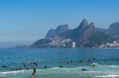Rio de Janeiro, Brezilya, 06-07-2023: Ipanema plajındaki Atlantik Okyanusu 'nda yüzen ve sörf yapan insanlar.