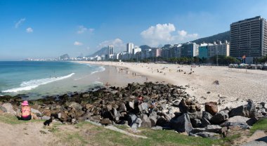 Rio de Janeiro, Brezilya, 06-07-2023: Gökdelenler ve Leme sahilinin kristal suyu ile şehrin panoramik manzarası Pedra do Leme (Leme Kayası), bitki örtüsüyle dolu kayalık bir tepe