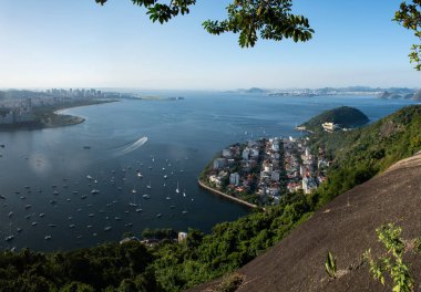 Rio de Janeiro, Brezilya, 06-07-2023: Rio silueti solda, Urca ilçesi aşağıda ve Niteroi belediyesi sağda Morro da Urca (Urca Dağı), Sugarloaf Kablo Arabasının ilk durağı. 