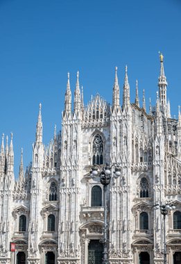 Milano Katedrali ve meydan manzarası. Duomo di Milano. Katedralin ön cephesine beyaz mermerden bir göz atın. Buttresses, pinnacles ve spiers. Madonnina Heykeli. Lombardia 'da. 07-09-2023. İtalya