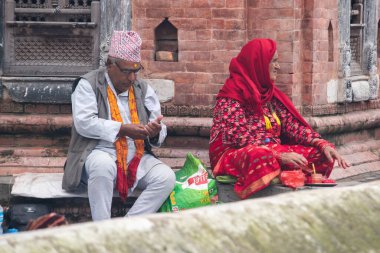 Katmandu, Nepal, 10-03-2023: Shiva 'ya adanmış ünlü Hindu tapınağı Pashupatinath Tapınağı' ndaki yakma töreninden önce kutsal Bagmati nehri boyunca Brahman ailesini bekleyen bir Nepali Hindu ailesi.