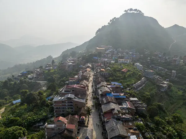 Nepal 'in Bandipur kasabasını çevreleyen tanrıça ışınları ve sisle aydınlatılmış hava manzarası. Dükkanları ve ticari faaliyetleri olan ana cadde