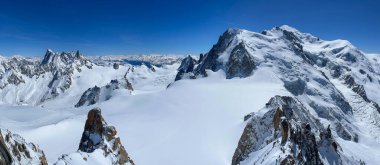 Haute-Savoie, Fransa, 04-25-2024: LAiguille du Midi 'den panoramik manzara (öğle vakti iğne), Aiguilles de Chamonix' in en yüksek kulesi (3.842 metre), Mont Blanc toplu tepeleri ve İtalyan Alpleri