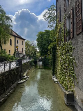 Annecy, Haute-Savoie, France, 04-21-2024: the old town skyline and the crystal clear waters of the Thiou River flowing in one of the canals that made Annecy famous as the French Venice clipart