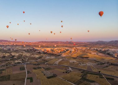 Şafak vakti, Kapadokya 'nın vadilerinde uçan sıcak hava balonlarının hava görüntüsü, 07-08-2019. Türkiye