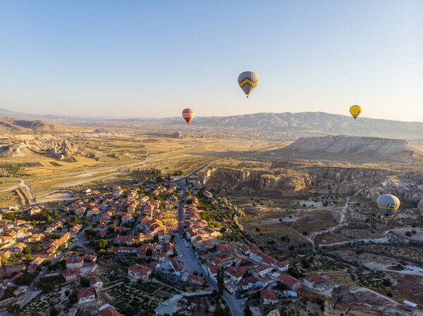 Aerial view of hot air balloons at dawn against the light, flying over the valleys of Cappadocia, 07-08-2019. Turkey