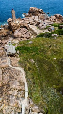 Fransa 'nın Perros-Guirec kentinde bulunan Ploumanac' h Deniz Feneri 'nin hava manzarası. Yapı pembe granitten oluşuyor. Brittany kıyıları, okyanus dalgaları kayalara çarpıyor. Kıyı yolu