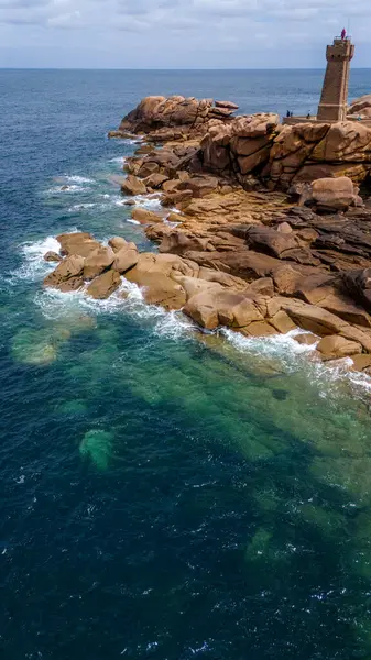 stock image Aerial view of Ploumanac'h Lighthouse, located in Perros-Guirec, France. The structure is composed of pink granite.  Brittany coast, ocean waves crashing on the rocks. Coastal path