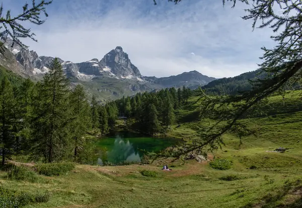 stock image Valle d'Aosta, Italy, 08-15-2024: view of Lago Blu (Blue Lake), small body of water surrounded by century-old larch trees with view of Cervino (Matterhorn), 4,478 meters mountain of Central Alps