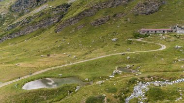 Cervino Dağı 'nın havadan görünüşü, The Matterhorn, Breuil-Cervinia' dan görülüyor. Buzullardan inen yeşil vadiler ve su yolları. İtalya. Cervinia vadisinde yollar ve patikalar, mülteciler ve dağ çayır kiliseleri