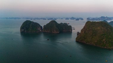 Aerial view of the H Long Bay, Halong Bay is a UNESCO World Heritage Site and popular travel destination in Quang Ninh province, Vietnam. Cruise ships and islands alternate in the bay. Sunset