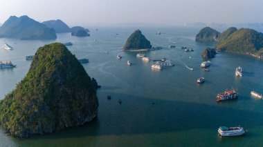 Halong Körfezi 'nin havadan görünüşü, UNESCO Dünya Mirası Bölgesi ve Quang Ninh, Vietnam' da popüler bir seyahat merkezidir. Körfezde dönüşümlü olarak seyahat eden gemiler ve adalar. Gün batımı
