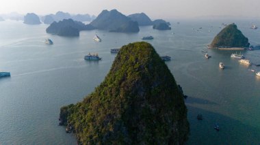 Halong Körfezi 'nin havadan görünüşü, UNESCO Dünya Mirası Bölgesi ve Quang Ninh, Vietnam' da popüler bir seyahat merkezidir. Körfezde dönüşümlü olarak seyahat eden gemiler ve adalar. Gün batımı