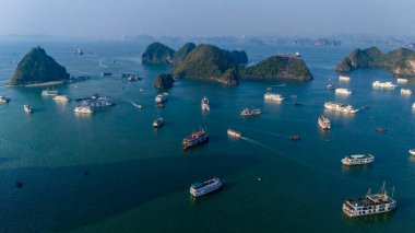 Halong Körfezi 'nin havadan görünüşü, UNESCO Dünya Mirası Bölgesi ve Quang Ninh, Vietnam' da popüler bir seyahat merkezidir. Körfezde dönüşümlü olarak seyahat eden gemiler ve adalar. Gün batımı
