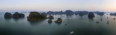 Halong Körfezi 'nin havadan görünüşü, UNESCO Dünya Mirası Bölgesi ve Quang Ninh, Vietnam' da popüler bir seyahat merkezidir. Körfezde dönüşümlü olarak seyahat eden gemiler ve adalar. Gün batımı