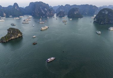 Halong Körfezi 'nin havadan görünüşü, UNESCO Dünya Mirası Bölgesi ve Quang Ninh, Vietnam' da popüler bir seyahat merkezidir. Körfezde dönüşümlü olarak seyahat eden gemiler ve adalar. Gün batımı