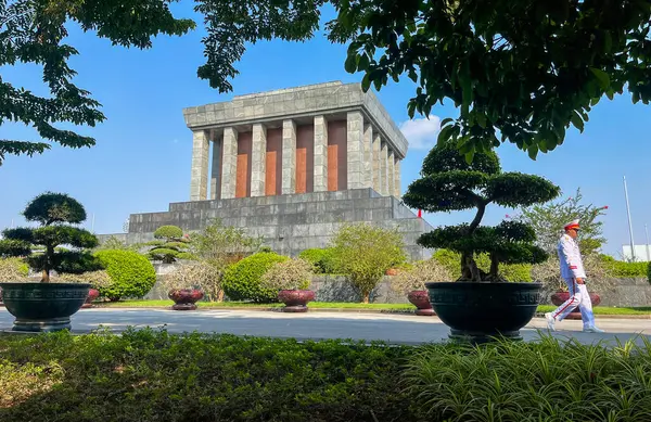 Hanoi, Vietnam, 06-11-2024: Ho Chi Minh Anıtmezarı 'nın arkasında yürüyen gardiyan, 1975 yılında Vietnamlı lider Ho Chi Minh' e adanmış ve Lenin 'in Moskova' daki mozolesinden esinlenilmiş bir cenaze anıtı.