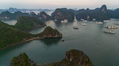 Ha Long Körfezi 'nin havadan görünüşü, UNESCO Dünya Mirası Bölgesi ve Qung Ninh, Vietnam' da popüler bir seyahat merkezidir. Körfezde dönüşümlü olarak seyahat eden gemiler ve adalar. Gün batımı