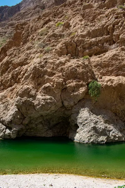 Umman, Ortadoğu, 03-25-2025: Wadi Shab, kristal berrak su havuzlarının ve bir mağaranın içindeki gizli şelalenin bulunduğu dar bir kanyon, Hajar Dağları 'nın doğusundan Umman Körfezi' ne akıyor.