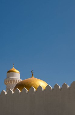 Umman, 03-06-2025: Mavi gökyüzü ve altın kubbeli bir minare, Arap Yarımadası 'nın kuzeydoğu noktası olan Musandam Yarımadası' nın (Ruus Al Jibal) birçok camisinden biri. Çöl manzarası
