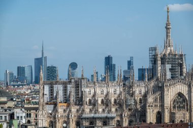 Milan 'ın gökdelenleri, çatıları ve gökdelenleri görünüyor. Ön planda Duomo ve arka planda Unicredit gökdelenli Porta Nuova alanı. 04-12-2025. İtalya
