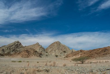 Umman, Ortadoğu: Umman Sultanlığı 'nın yollarında gitmek, dağların panoramik manzarası ve uzak köylerden geçen Muscat ve Nizwa arasındaki yolda çöl manzarası.