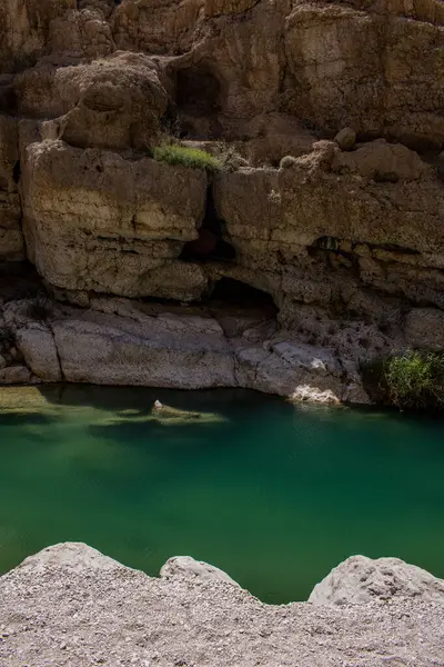 Umman, Ortadoğu, 03-25-2025: Wadi Shab, kristal berrak su havuzlarının ve bir mağaranın içindeki gizli şelalenin bulunduğu dar bir kanyon, Hajar Dağları 'nın doğusundan Umman Körfezi' ne akıyor.