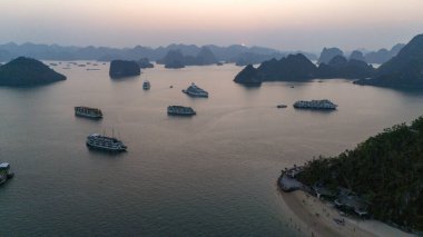 Ha Long Körfezi 'nin havadan görünüşü, UNESCO Dünya Mirası Bölgesi ve Qung Ninh, Vietnam' da popüler bir seyahat merkezidir. Körfezde dönüşümlü olarak seyahat eden gemiler ve adalar. Gün batımı