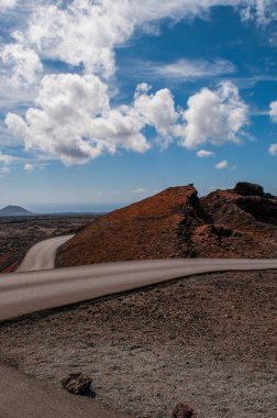 Lanzarote, Kanarya Adaları, İspanya: nefes kesici çöl manzarası ve Timanfaya Ulusal Parkı 'ndaki yol (Parque Nacional de Timanfaya), tamamen volkanik topraktan oluşan ünlü jeolojik park