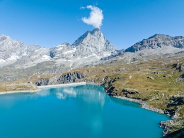Aerial view of the Matterhorn, Breuil-Cervinia. Green valleys and waterways flowing from the glaciers. Goillet reservoir and dam