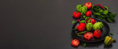 Yeşil ve kırmızı kurdeleli domates, Amerikan ya da Floransa usulü. Olgun sebzeler, acı biber, taze defne yaprakları. Modaya uygun sert ışık, koyu gölge, taş beton zemin, düz döşeme, pankart biçimi