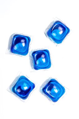 Çamaşır makinesi için deterjanlı kapsüller beyaz arka planda izole edilmiş. Çamaşır kapsülleri, sıvı renkli jel. Ekonomik ve çevre dostu çamaşır yıkama, düz uzanma