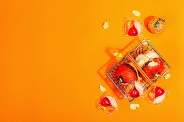 Makine yıkama için satış konsepti. Deterjanlı kapsüller ve geleneksel sepetli sonbahar dekorları. Çamaşır kapsülleri, sonbahar tarzı. Eko dostu çamaşır yıkama. Turuncu arkaplan, üst görünüm