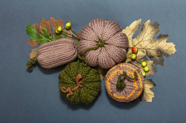 Geleneksel sonbahar geçmişi. Örgü balkabağı, el yapımı konsept. Modaya uygun sert ışık, koyu gölge, düz yatış, mat gri arkaplan, üst görünüm