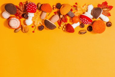 Geleneksel sonbahar geçmişi. Farklı örülmüş mantar çeşitleri, el yapımı konsept. Modaya uygun sert ışık, koyu gölge, düz döşeme, parlak turuncu arka plan, üst manzara