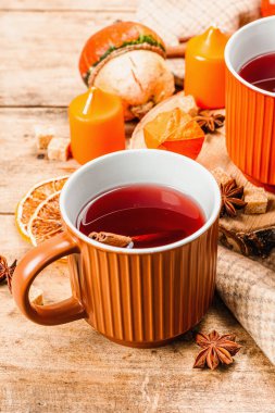Baharatlı sıcak çay. Sonbahar neşesi, geleneksel sonbahar içeceği. Balkabağı, eşarp, mumlar, yıldız anason, tarçın. Tahta kaplama arka plan, kapat