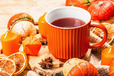 Baharatlı sıcak çay. Sonbahar neşesi, geleneksel sonbahar içeceği. Balkabağı, eşarp, mumlar, yıldız anason, tarçın. Tahta kaplama arka plan, kapat