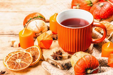 Baharatlı sıcak çay. Sonbahar neşesi, geleneksel sonbahar içeceği. Balkabağı, eşarp, mumlar, yıldız anason, tarçın. Tahta kaplama arka plan, kapat