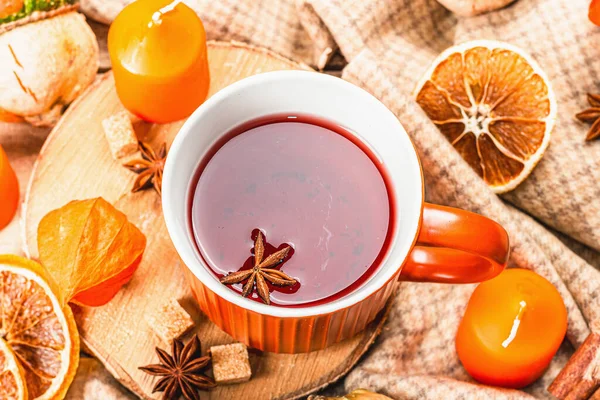 stock image Spicy hot tea. Autumn good mood, traditional fall beverage in cups. Pumpkin, scarf, candles, star anise, cinnamon. Wooden boards background, top view