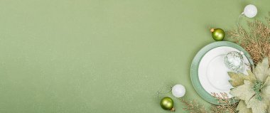 Boş seramik tabaklar ve modaya uygun Savannah Green renk arka planında geleneksel aksesuarlar. Şenlikli Yeni Yıl çatal bıçak takımı, düz döşeme, afiş biçimi