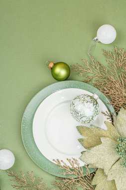 Boş seramik tabaklar ve modaya uygun Savannah Green renk arka planında geleneksel aksesuarlar. Şenlikli Yeni Yıl çatal bıçak takımı, düz yatak, üst manzara