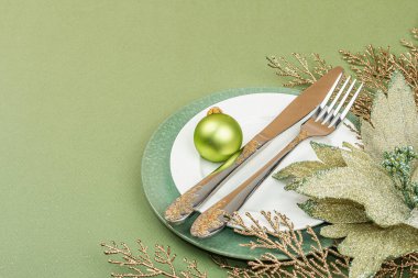 Boş seramik tabaklar ve modaya uygun Savannah Green renk arka planında geleneksel aksesuarlar. Şenlikli Yeni Yıl çatal bıçak takımı, düz döşeme, kopyalama alanı