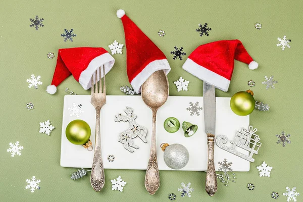 老式餐具与传统圣诞装饰 新年的象征 餐桌摆设 明亮的灯光 黑暗的阴影 时尚的萨凡纳绿色背景 顶视图 — 图库照片