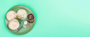 Donmuş hake parçaları. Turkuaz renginde deniz balığı filetosu, sağlıklı yemek pişirmek için ham malzeme. Baharatlar, taze biberiye, limon, pankart biçimi