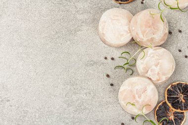 Donmuş hake parçaları. Kayalık arka planda deniz balığı filetosu, sağlıklı yemek pişirmek için ham malzeme. Baharatlar, taze biberiye, limon, üst manzara.