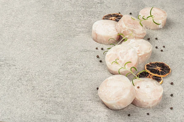 冷凍ハケの塊 石の背景に海洋魚の切り身 健康的な食品を調理するための原材料 スパイス 新鮮なローズマリー レモン コピースペース — ストック写真