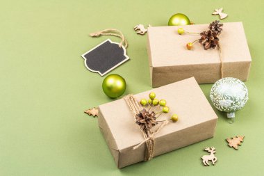 Sıfır atık hediye konsepti. El yapımı eko tarzı, doğal yeni yıl, Şükran Günü, Noel süsü. Kraft kâğıdı ambalajsız. Moda Savannah Green renk arkaplanı, düz uzanma, kopyalama alanı