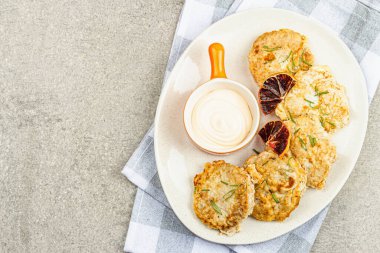 Hamurda kızartılmış fileto. Sos, taze biberiye, limon dilimleri. Vejetaryen sağlıklı gıda konsepti. Taş beton zemin, düz zemin, üst manzara