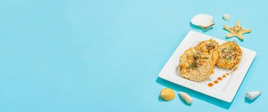 Hamurda kızartılmış fileto. Sos, taze biberiye, deniz dekoru. Vejetaryen sağlıklı gıda konsepti. Modaya uygun sert ışık, koyu gölge, mavi arkaplan, pankart biçimi